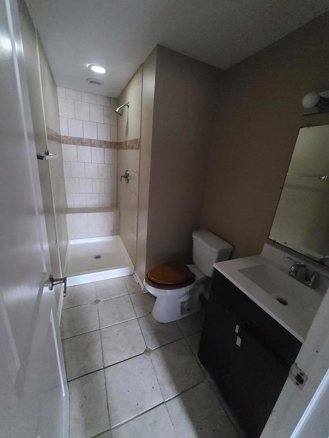 full bath with a shower stall, tile patterned floors, vanity, and toilet