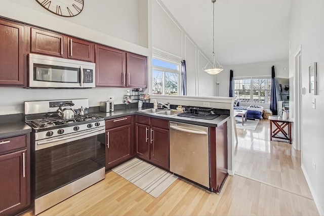 1412 Plantain Dr, Minooka, IL 60447 - kitchen with a peninsula, dark countertops, stainless steel appliances, and a sink