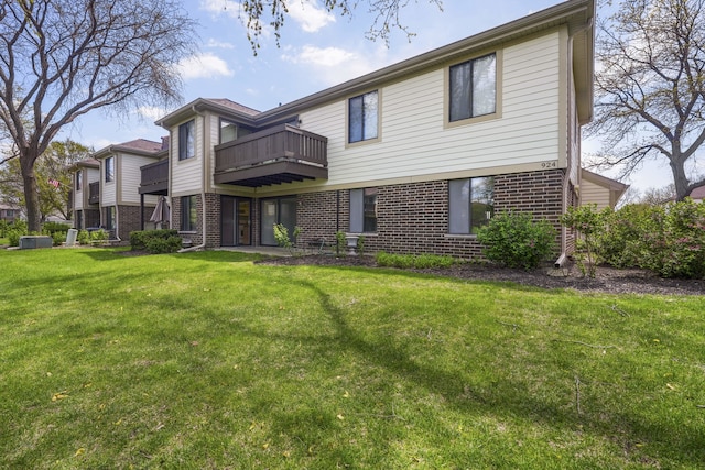 924 Coach Rd Unit 1, Palatine, IL 60074 - rear view of house featuring brick siding, a lawn, and a balcony
