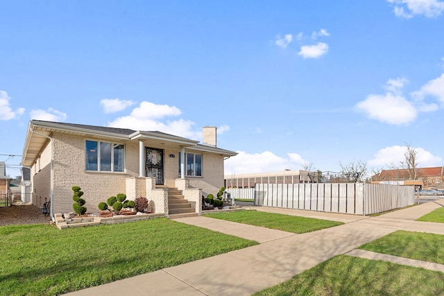 bungalow with brick siding, a chimney, a front lawn, and fence