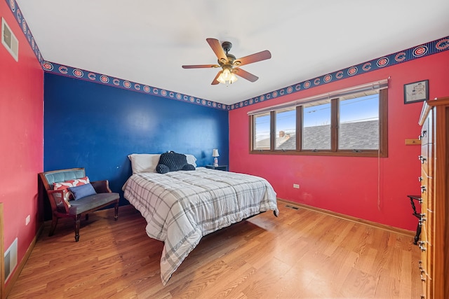 bedroom with ceiling fan, baseboards, visible vents, and light wood-style flooring