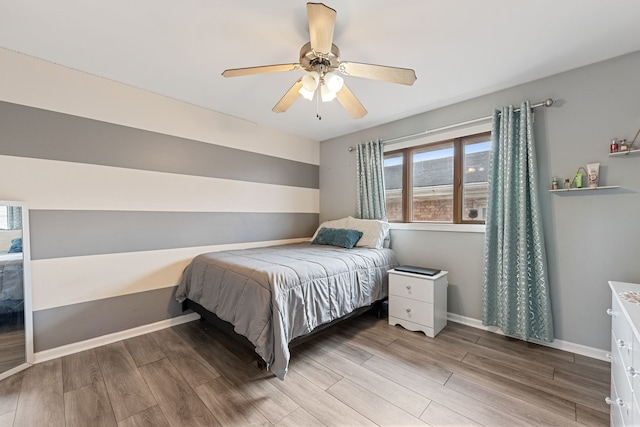 bedroom featuring wood finished floors, baseboards, and ceiling fan