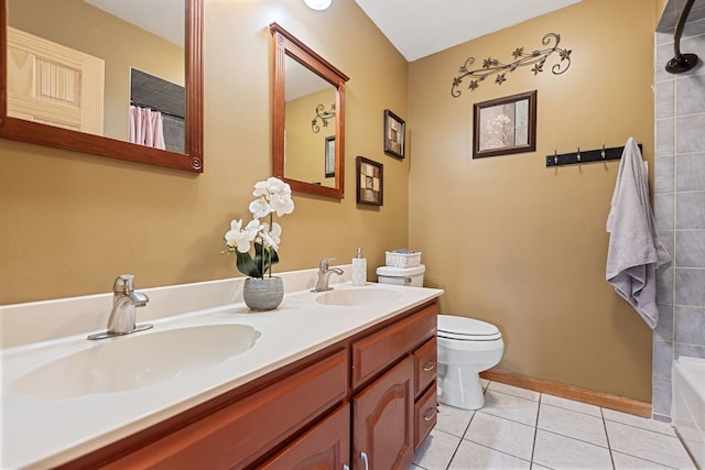bathroom featuring double vanity, tile patterned flooring, toilet, and a sink