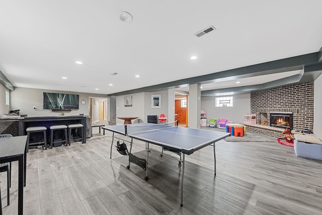 playroom featuring recessed lighting, light wood-style flooring, visible vents, and a fireplace