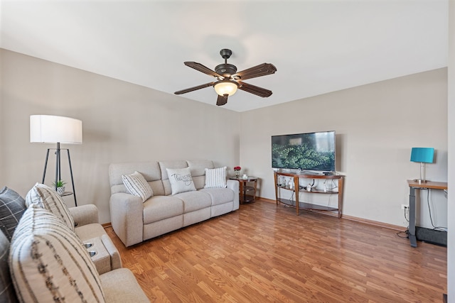 living area with light wood finished floors and a ceiling fan