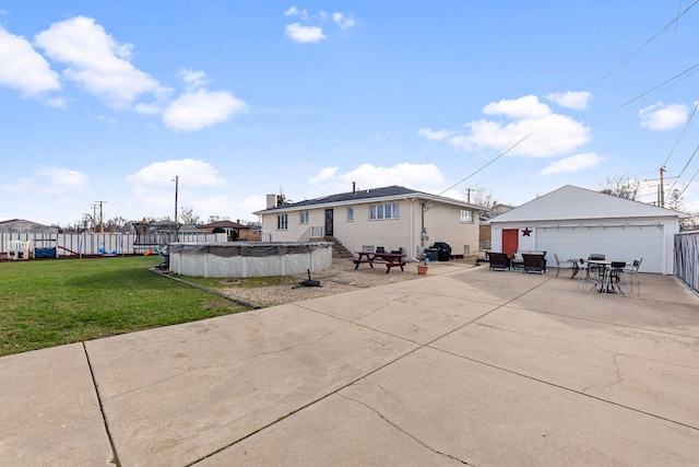 rear view of house featuring a fenced in pool, fence, a garage, a lawn, and an outdoor structure