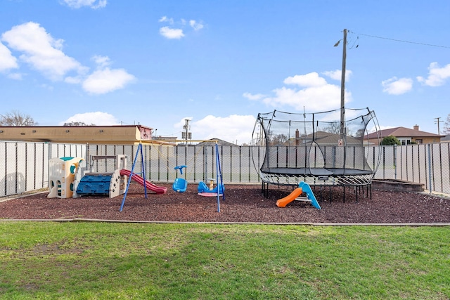 community playground with a trampoline, a lawn, and a fenced backyard