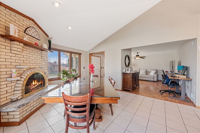 dining area with a ceiling fan, baseboards, light tile patterned flooring, and a fireplace