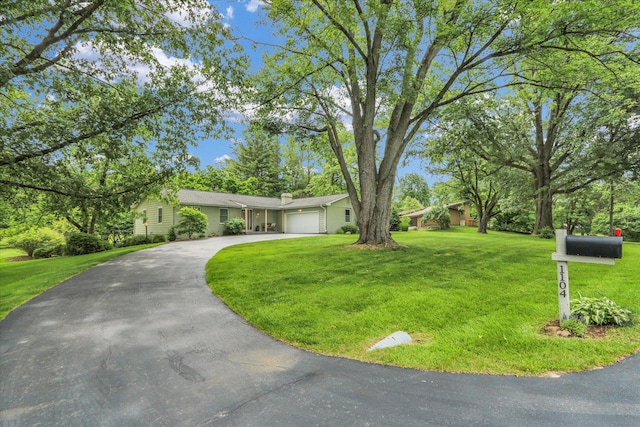 1104 Parkview Dr, Mahomet, IL 61853 - view of front of property with asphalt driveway, a garage, a front yard, and a chimney