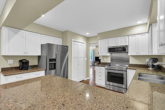 1104 Parkview Dr, Mahomet, IL 61853 - kitchen featuring appliances with stainless steel finishes, white cabinetry, recessed lighting, and dark stone countertops