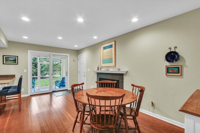 1104 Parkview Dr, Mahomet, IL 61853 - dining area with hardwood / wood-style floors, a tiled fireplace, and recessed lighting
