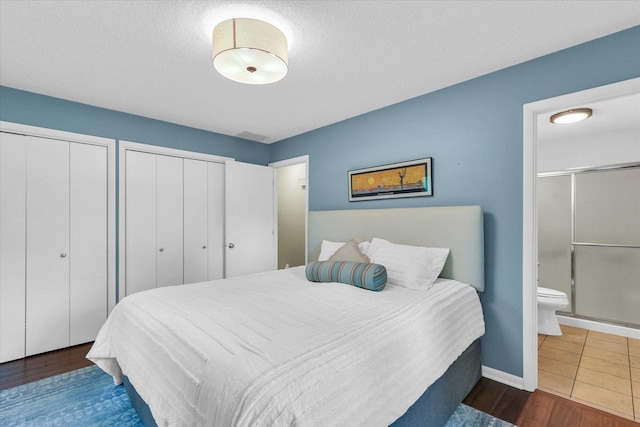 1104 Parkview Dr, Mahomet, IL 61853 - bedroom with two closets, ensuite bath, and wood finished floors