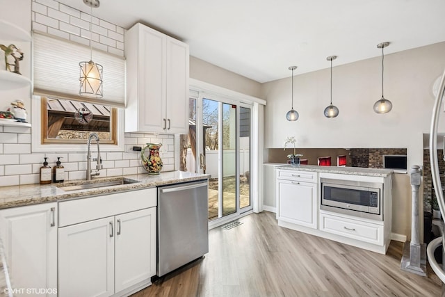 kitchen with decorative backsplash, white cabinetry, a sink, and appliances with stainless steel finishes