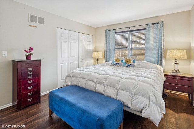 bedroom featuring visible vents, a closet, baseboards, and wood finished floors