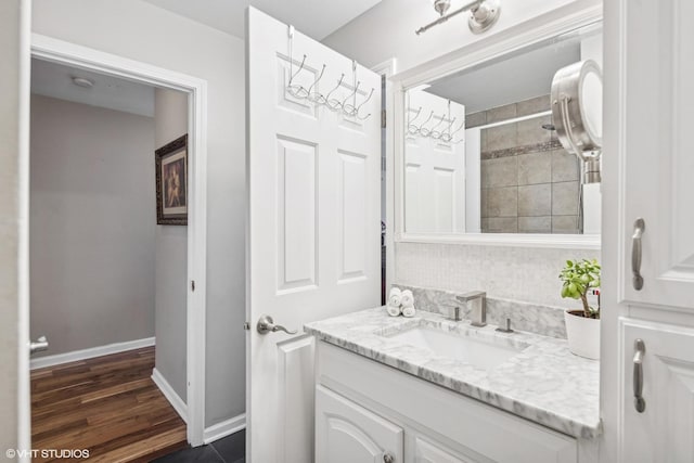 bathroom with wood finished floors, vanity, and baseboards