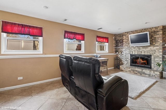 tiled living area with visible vents, baseboards, and a brick fireplace