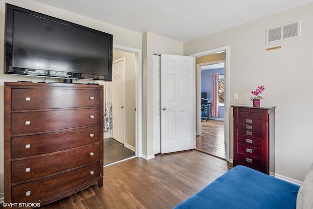 bedroom featuring dark wood-style flooring, visible vents, and baseboards
