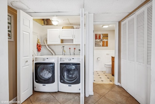 laundry room featuring cabinet space, independent washer and dryer, wainscoting, and light tile patterned flooring