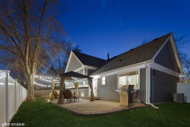 back of house featuring a patio, a fenced backyard, central AC, and a lawn