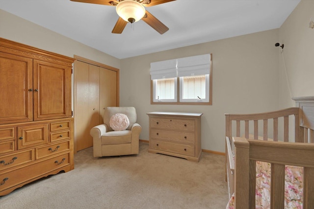 bedroom with light colored carpet, baseboards, a ceiling fan, and a closet
