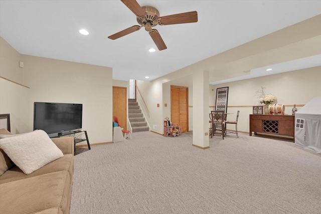 carpeted living area with ceiling fan, baseboards, stairs, and recessed lighting
