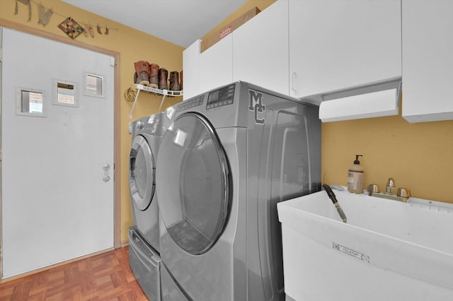 laundry room featuring cabinet space, a sink, and separate washer and dryer