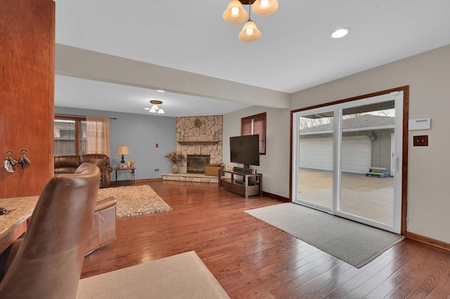 living area featuring baseboards, wood finished floors, and a healthy amount of sunlight