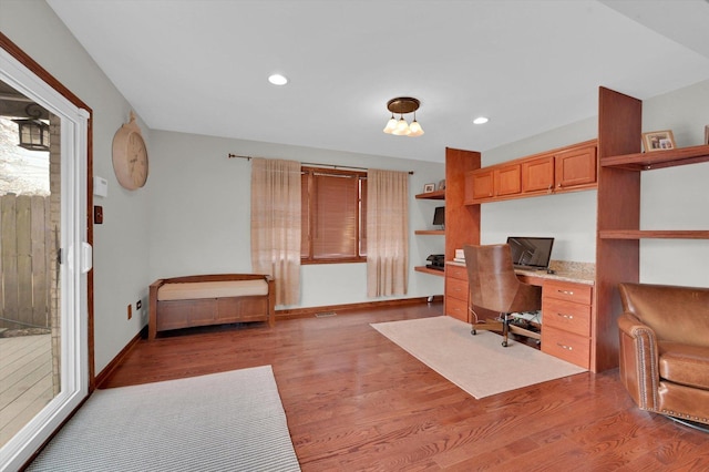 office space with recessed lighting, built in study area, light wood-style floors, and baseboards