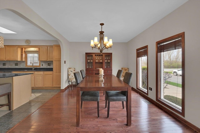 dining room with plenty of natural light, arched walkways, and a chandelier