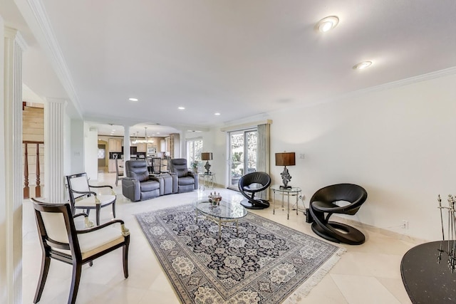 living area featuring ornate columns, an inviting chandelier, crown molding, and recessed lighting