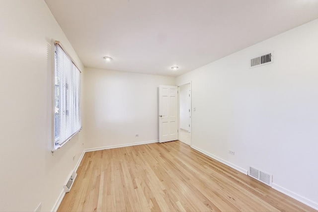 empty room featuring visible vents, baseboards, and light wood-style floors