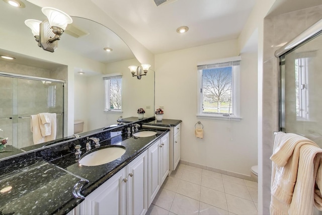 full bath featuring plenty of natural light, a stall shower, a sink, and toilet
