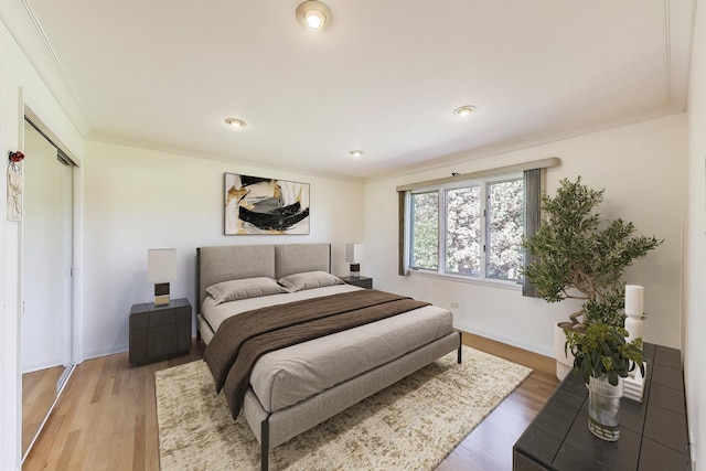 bedroom featuring crown molding, light wood-style flooring, recessed lighting, and baseboards