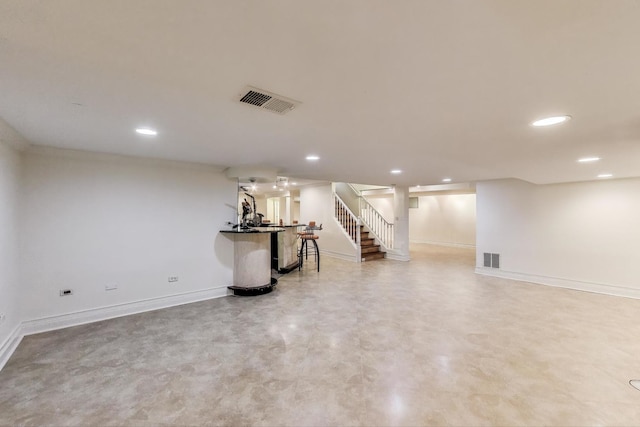 finished below grade area featuring recessed lighting, baseboards, visible vents, and stairway