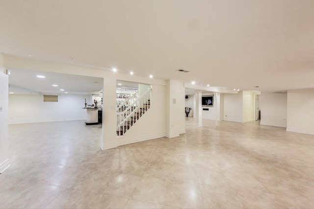 finished below grade area with stairway, baseboards, visible vents, and recessed lighting