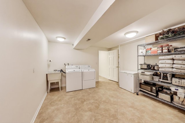 washroom with visible vents, washer and clothes dryer, laundry area, and baseboards