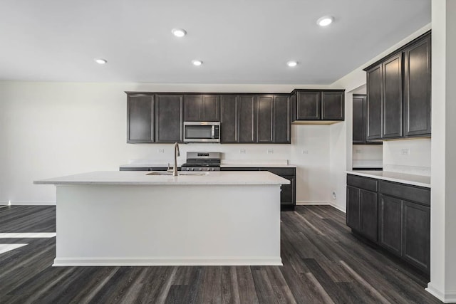 11381 Wildridge Ln, Huntley, IL 60142 - kitchen featuring dark wood-style floors, light countertops, a center island with sink, stainless steel appliances, and a sink