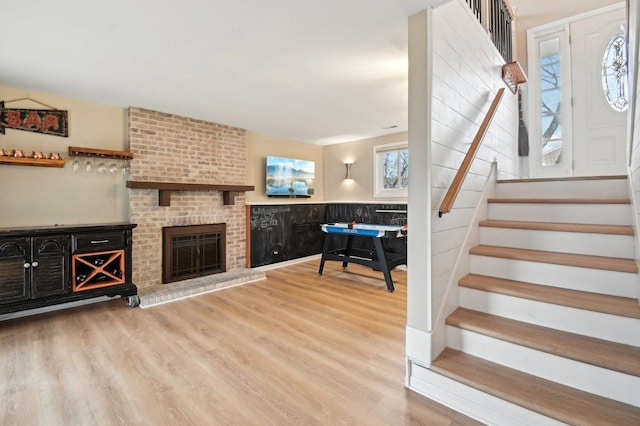interior space with wood finished floors, stairs, and a fireplace