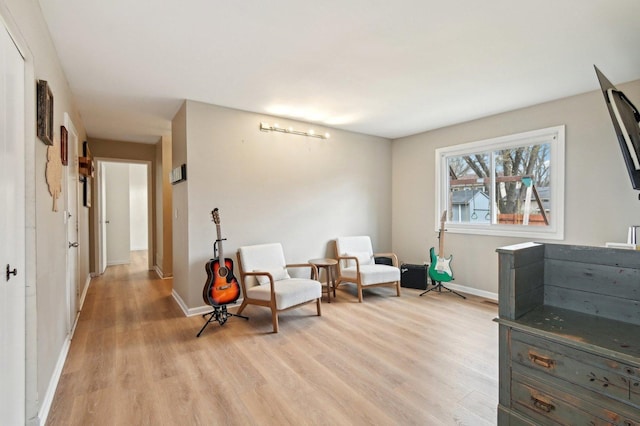 living area with light wood-style flooring and baseboards