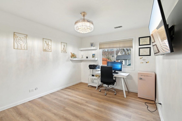 office area featuring baseboards, a notable chandelier, wood finished floors, and visible vents