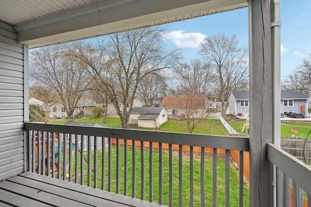 wooden terrace with a yard, fence, and a residential view