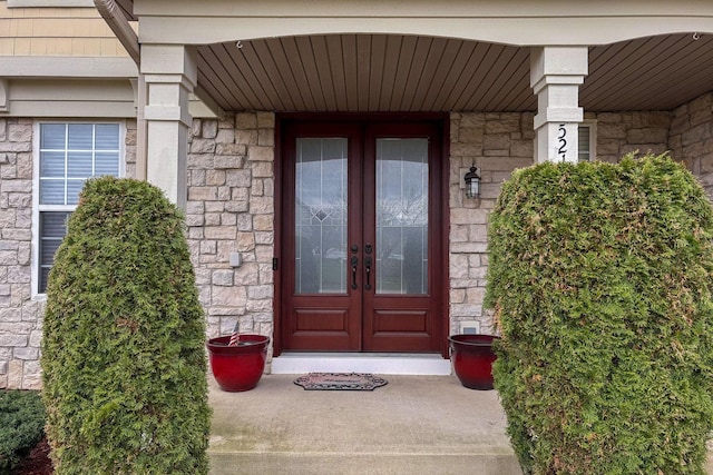 entrance to property featuring french doors and stone siding