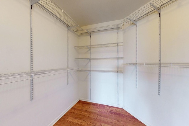 walk in closet with wood finished floors