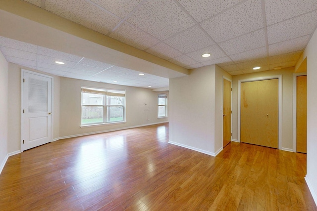 spare room with baseboards, recessed lighting, a paneled ceiling, and wood finished floors