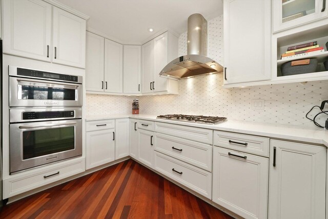 2041 W Division St Unit 304, Chicago, IL 60622 - kitchen featuring dark wood-style floors, light countertops, wall chimney exhaust hood, white cabinets, and appliances with stainless steel finishes