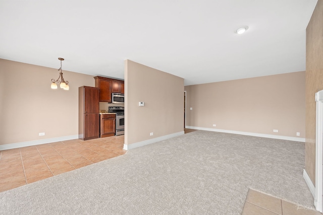 unfurnished living room featuring a notable chandelier, light colored carpet, and baseboards