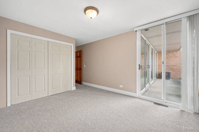 unfurnished bedroom with visible vents, access to exterior, a closet, and carpet floors