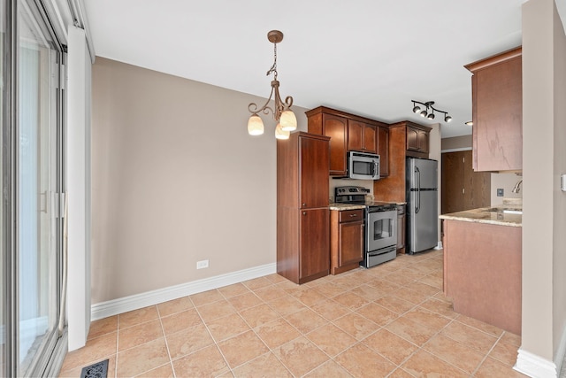 kitchen featuring an inviting chandelier, light stone countertops, visible vents, stainless steel appliances, and decorative light fixtures