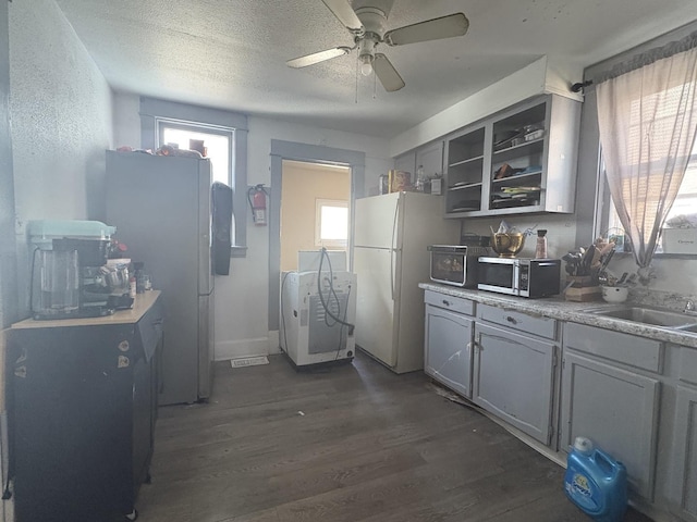 kitchen featuring dark wood-style flooring, freestanding refrigerator, open shelves, and ceiling fan