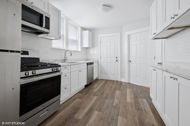 7440 S Ingleside Ave, Chicago, IL 60619 - kitchen with stainless steel appliances, a sink, dark wood-style flooring, and decorative backsplash